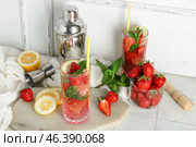 Glass of fresh strawberry mojito with shaker and jigger on white tile table. Стоковое фото, фотограф Pixel_shot / Фотобанк Лори