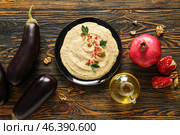 Plate of tasty baba ghanoush with ingredients on wooden background. Стоковое фото, фотограф Pixel_shot / Фотобанк Лори