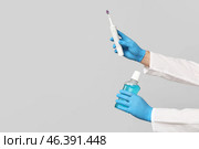 Dentist hands with electric toothbrush and bottle of mouth rinse on grey background. World Dentist Day. Стоковое фото, фотограф Pixel_shot / Фотобанк Лори