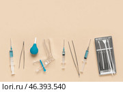 Gynecological speculum with pap smear test tools, enema and syringes on beige background. Стоковое фото, фотограф Pixel_shot / Фотобанк Лори
