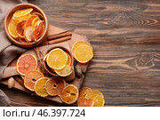 Bowls with dried citrus fruits, nutmegs and cinnamon on wooden background. Стоковое фото, фотограф Pixel_shot / Фотобанк Лори