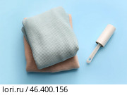 Lint roller with clothes on color background. Стоковое фото, фотограф Pixel_shot / Фотобанк Лори