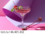 Glass of tasty cosmopolitan cocktail and spoon on color background. Стоковое фото, фотограф Pixel_shot / Фотобанк Лори
