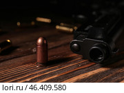 Gun with bullet on wooden table. Стоковое фото, фотограф Pixel_shot / Фотобанк Лори