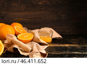 Squeezer with fresh oranges and juice on dark table. Стоковое фото, фотограф Pixel_shot / Фотобанк Лори
