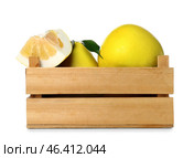 Wooden box of whole and cut sweet ripe pomelo fruits on white background. Стоковое фото, фотограф Pixel_shot / Фотобанк Лори