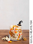 Jar with tasty popcorn, candy corns and pretzels on wooden table. Halloween celebration. Стоковое фото, фотограф Pixel_shot / Фотобанк Лори