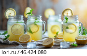 Refreshing lemonade with mint served in mason jars, perfect for summer gatherings and picnics. Стоковое AI-изображение, AI-художник Сергей Толмачёв / Фотобанк Лори