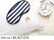 Foam earplugs, sleeping mask, pillow, alarm clock and pills on light background. Стоковое фото, фотограф Pixel_shot / Фотобанк Лори