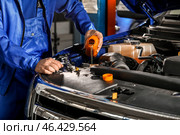 Male mechanic refilling car oil in service center. Стоковое фото, фотограф Pixel_shot / Фотобанк Лори