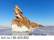 Scenic winter landscape of frozen Baikal Lake. View of Dragon Cape on edge of Ogoy Island - natural landmark and popular place of tourists against background of blue sky in sunny day. Natural background. Стоковое фото, фотограф Виктория Катьянова / Фотобанк Лори