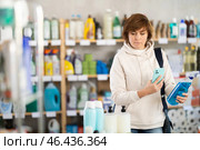 Woman client scans QR code on package and downloads promo code to purchase bathroom cleaner spray. Стоковое фото, фотограф Яков Филимонов / Фотобанк Лори