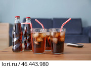 Бутылки и стаканы холодной колы на столе. Стоковое фото, фотограф Pixel_shot / Фотобанк Лори