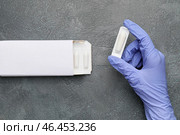 Рука врача с геморроидальными суппозиториями на сером фоне. Стоковое фото, фотограф Pixel_shot / Фотобанк Лори