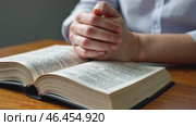 Person is praying in front of a book. Стоковое AI-видео, аниматор Sergey Grishin / Фотобанк Лори