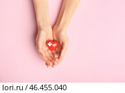Женские руки с красным сердцем на цветном фоне. Кардиологическая концепция. Стоковое фото, фотограф Pixel_shot / Фотобанк Лори