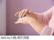 Зрелая женщина, применяя крем для рук на цветном фоне, крупным планом. Стоковое фото, фотограф Pixel_shot / Фотобанк Лори