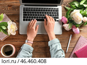 Женщина сидит за столом с ноутбуком и букет пионов. Стоковое фото, фотограф Pixel_shot / Фотобанк Лори