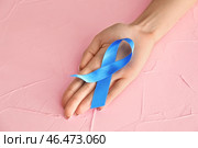 Женщина, держащая голубой лентой на цветном фоне. Концепция осведомленности рака толстой кишки. Стоковое фото, фотограф Pixel_shot / Фотобанк Лори