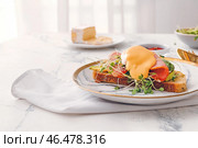 Вкусный бутерброд с флорентийским яйцом, беконом и авокадо на светлом фоне, крупным планом. Стоковое фото, фотограф Pixel_shot / Фотобанк Лори