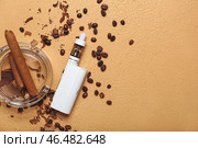 Современный вейп-мод, сигары и кофейные зерна на бежевом фоне. Стоковое фото, фотограф Pixel_shot / Фотобанк Лори