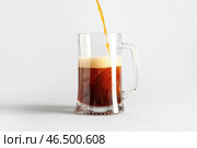 На сером фоне наливается вкусный квас в кружку. Стоковое фото, фотограф Pixel_shot / Фотобанк Лори