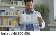 Doctor showing orthopedic pillow in medical office. Стоковое AI-видео, аниматор Юрий Поздников / Фотобанк Лори