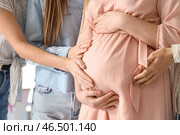 Женские друзья касаются живота молодой беременной женщины на вечеринке в честь беременности, крупный план. Стоковое фото, фотограф Pixel_shot / Фотобанк Лори