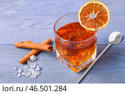 Бокал вкусного коктейля Олд-фэшн с апельсиновым кружком и палочками корицы на фиолетовом деревянном фоне. Стоковое фото, фотограф Pixel_shot / Фотобанк Лори
