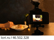 Женщина ест ресторанные блюда на дисплее профессиональной фотокамеры в студии. Стоковое фото, фотограф Pixel_shot / Фотобанк Лори
