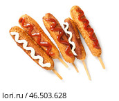 Вкусные корн-доги с майонезом и кетчупом на белом фоне. Стоковое фото, фотограф Pixel_shot / Фотобанк Лори