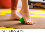 Спортивная молодая женщина массирует свою стопу с помощью мяча в спортзале, крупным планом. Стоковое фото, фотограф Pixel_shot / Фотобанк Лори