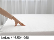 Женщина прикасается к мягкому ортопедическому матрасу на кровати дома, крупный план. Стоковое фото, фотограф Pixel_shot / Фотобанк Лори