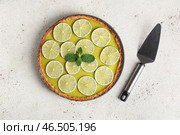 Тарелка с вкусным лаймовым тартом с мятой и лопаткой на белом фоне. Стоковое фото, фотограф Pixel_shot / Фотобанк Лори