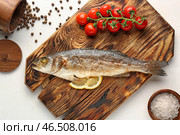 Деревянная доска с вкусно приготовленной сибас рыбы на белом фоне. Стоковое фото, фотограф Pixel_shot / Фотобанк Лори
