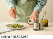 Шеф-повар посыпать вкусные равиоли на тарелку с травами. Стоковое фото, фотограф Pixel_shot / Фотобанк Лори