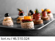 Тарелка с вкусными канапе на сером столе, крупным планом. Стоковое фото, фотограф Pixel_shot / Фотобанк Лори