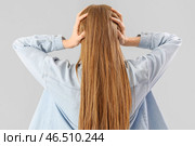 Молодая женщина страдает от громкого шума на сером фоне, вид сзади. Стоковое фото, фотограф Pixel_shot / Фотобанк Лори