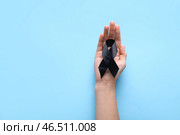 Женщина держит черную траурную ленту на голубом фоне. Стоковое фото, фотограф Pixel_shot / Фотобанк Лори