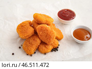 Бумажка для выпечки с вкусными кусочками и различными соусами на белом фоне. Стоковое фото, фотограф Pixel_shot / Фотобанк Лори