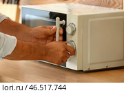 Зрелый мужчина разогревает еду в микроволновой печи, крупным планом. Стоковое фото, фотограф Pixel_shot / Фотобанк Лори