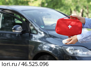 Женщина держит аптечку и бинты рядом с автомобилем на улице. Стоковое фото, фотограф Pixel_shot / Фотобанк Лори