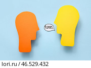 Бумажные человеческие головы и речевой пузырь со словом "СЛУХИ" на синем фоне. Концепция сплетен. Стоковое фото, фотограф Pixel_shot / Фотобанк Лори