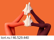 Женские ноги в колготках и стильных кедах на цветном фоне. Стоковое фото, фотограф Pixel_shot / Фотобанк Лори