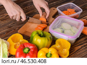 Женщина режет свежую морковь для заморозки на деревянной доске. Стоковое фото, фотограф Pixel_shot / Фотобанк Лори