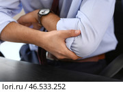 Молодой бизнесмен страдает от боли в локте на рабочем месте, крупным планом. Стоковое фото, фотограф Pixel_shot / Фотобанк Лори