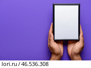 Мужчина держит пустую фоторамку на фоне фиолетового цвета. Стоковое фото, фотограф Pixel_shot / Фотобанк Лори