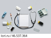 Стереоскоп, таблетки и блокнот на сером фоне. Стоковое фото, фотограф Pixel_shot / Фотобанк Лори