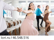 Couple in evening dresses enjoys pair dance boogie-woogie, interacting with each other on floor. Стоковое фото, фотограф Яков Филимонов / Фотобанк Лори