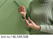 Женщина с бутылкой масла для кутикулы возле цветной стены. Стоковое фото, фотограф Pixel_shot / Фотобанк Лори